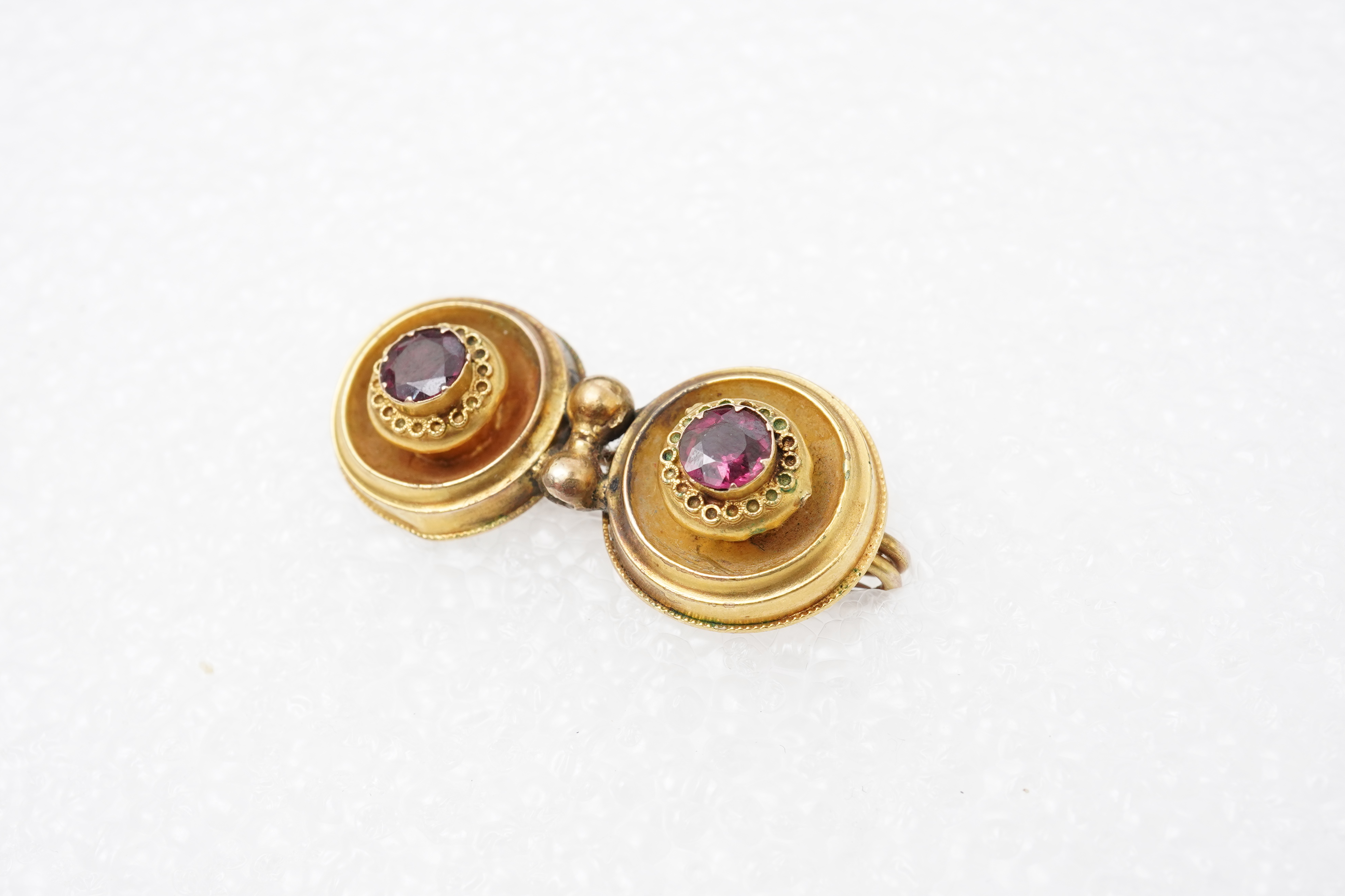 A Victorian ruby and gold double target brooch, late 19th century and later, composed of two roundels set with circular-cut garnets, with wirework details, length 3.7cm, gross weight approximately 3.5 grams